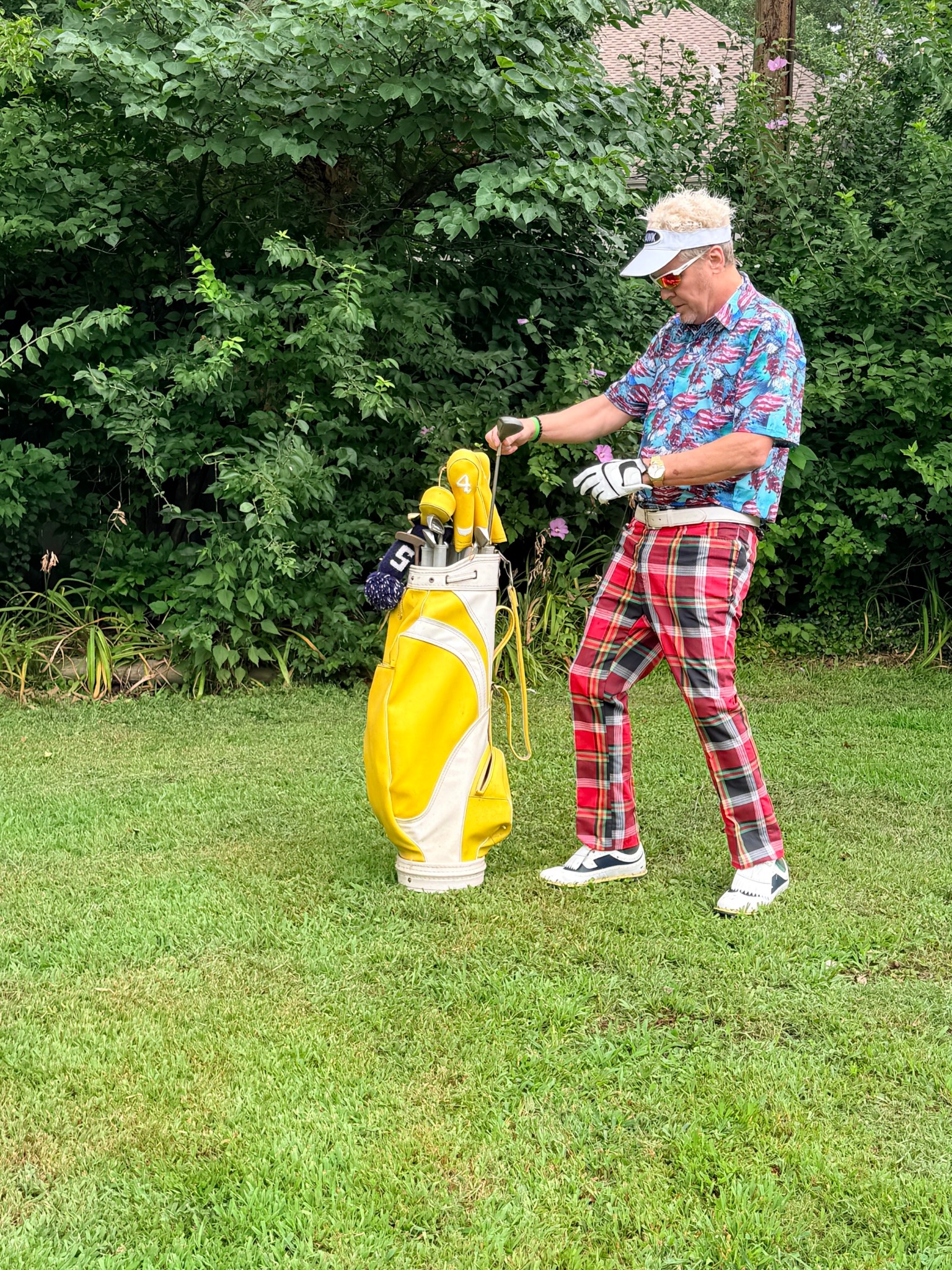 Lonnie Hawkins impersonator selecting a club from a yellow golf bag